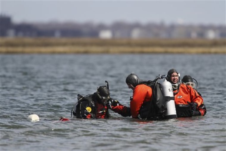 Suffolk County dive team police officers search for possible victims of a suspected serial killer in Hemlock Cove along Ocean Parkway near Cedar Beach, N.Y., Thursday, April 14, 2011. (AP Photo/Robert Mecea)